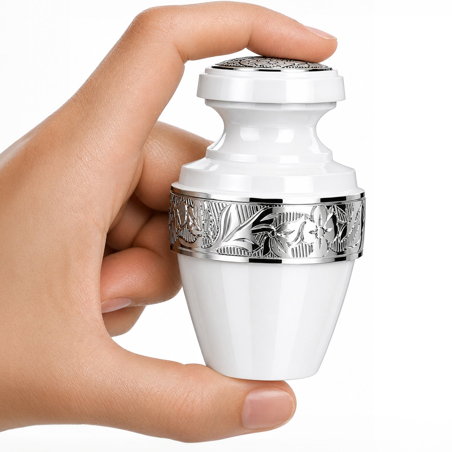 Classic White Small Keepsake Cremation Urn — white aluminum mini urn with silver floral banding held in hand on white background