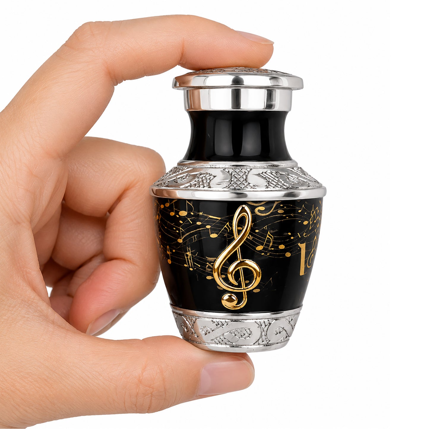 Black and gold musical notes keepsake cremation urn held in hand close up product shot