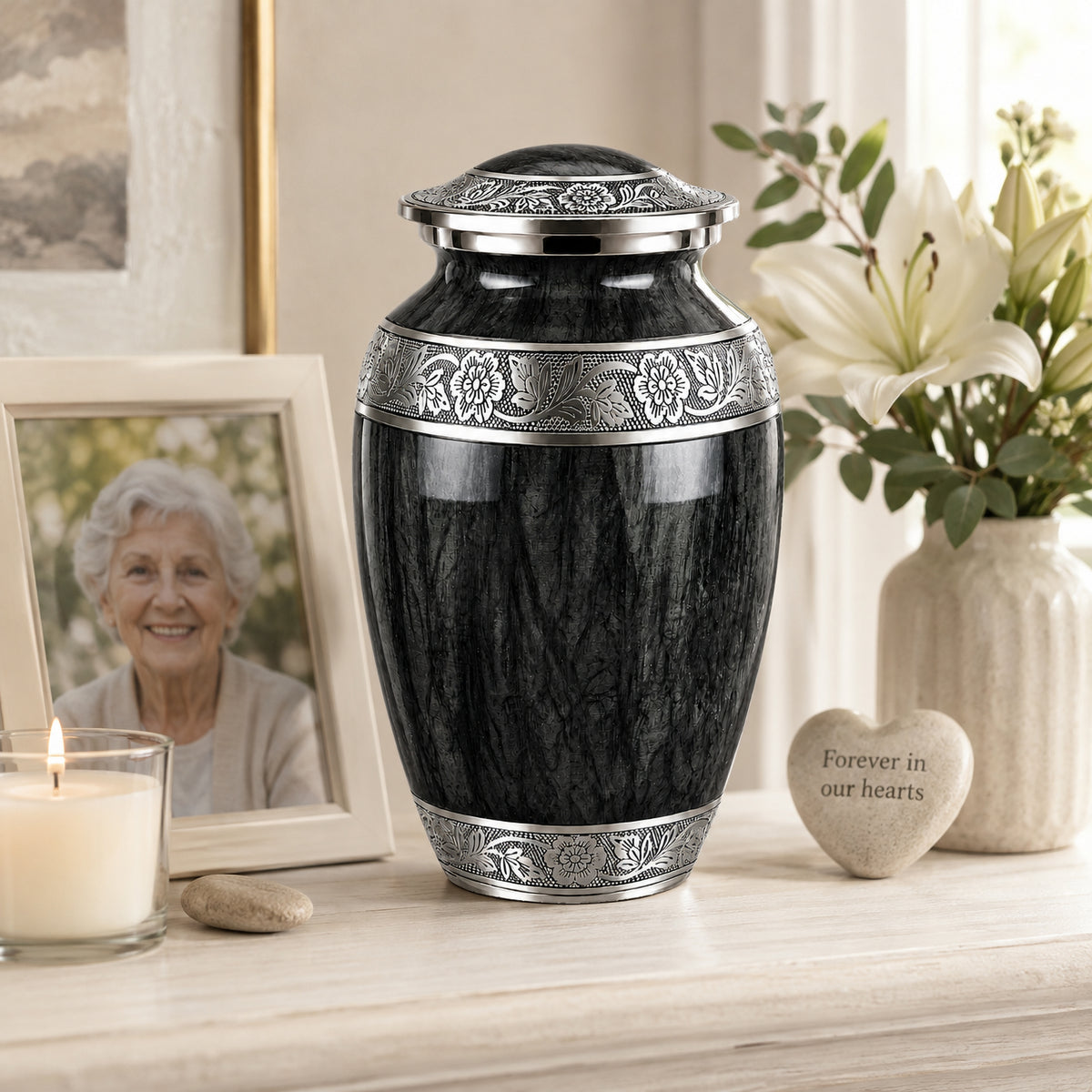 Black memorial urn displayed on wooden dresser beside framed photo of loved one, candle, and white hydrangeas