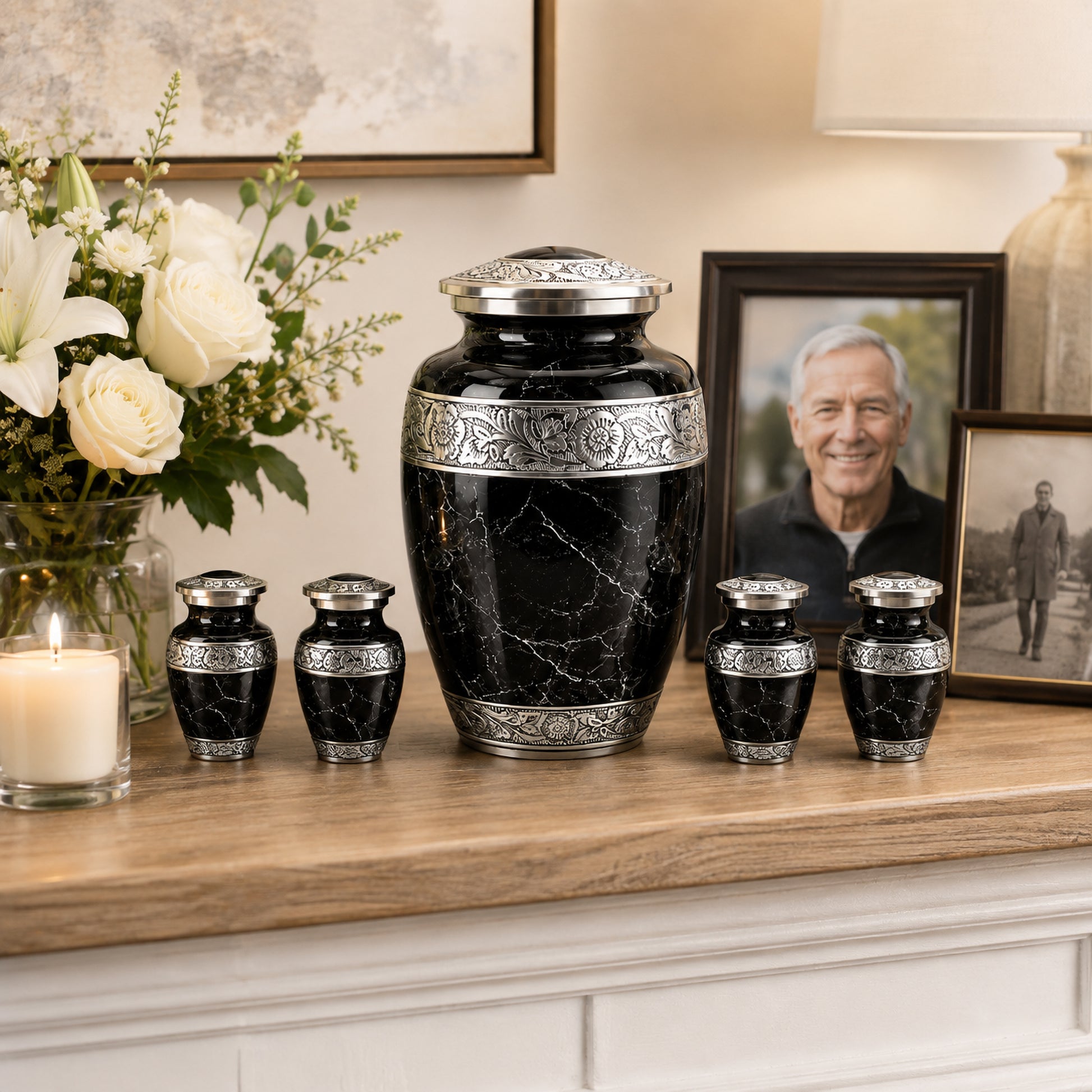Black marble cremation urn set displayed on mantle with flowers and family photo