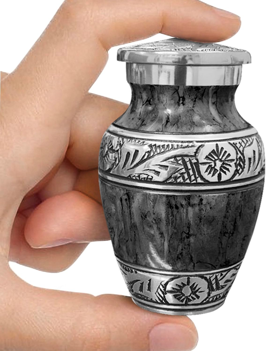 Dark gray watercolor small keepsake cremation urn held in hand