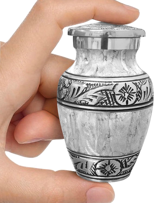 Light gray watercolor small keepsake cremation urn held in hand