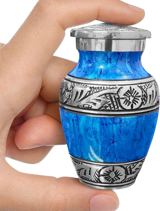 Light blue watercolor small keepsake cremation urn held between fingers showing size